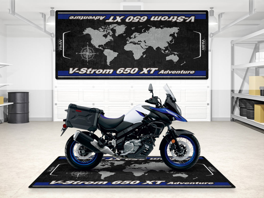 Suzuki V-Strom 650 XT Adventure in Pearl Vigor Blue parked on garage mat. Rug for motorcycle gear zone.