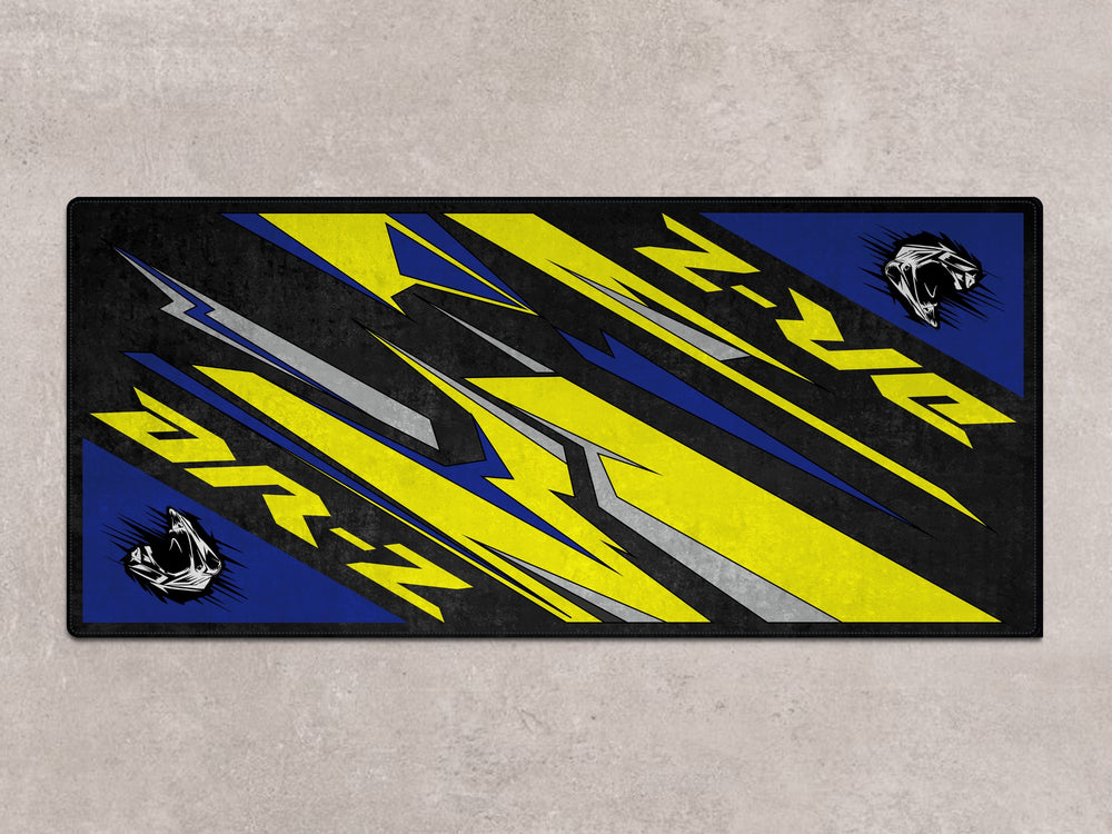 DR-Z motorcycle displayed on a vibrant pit mat. A stylish floor cover for garage floor protection and bike storage.