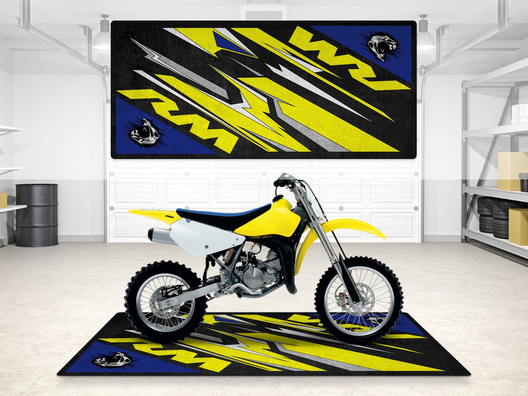 Suzuki RM in Champion Yellow parked on a dirt-ready garage mat. Rugged floor cover for motocross pit or showroom setup.