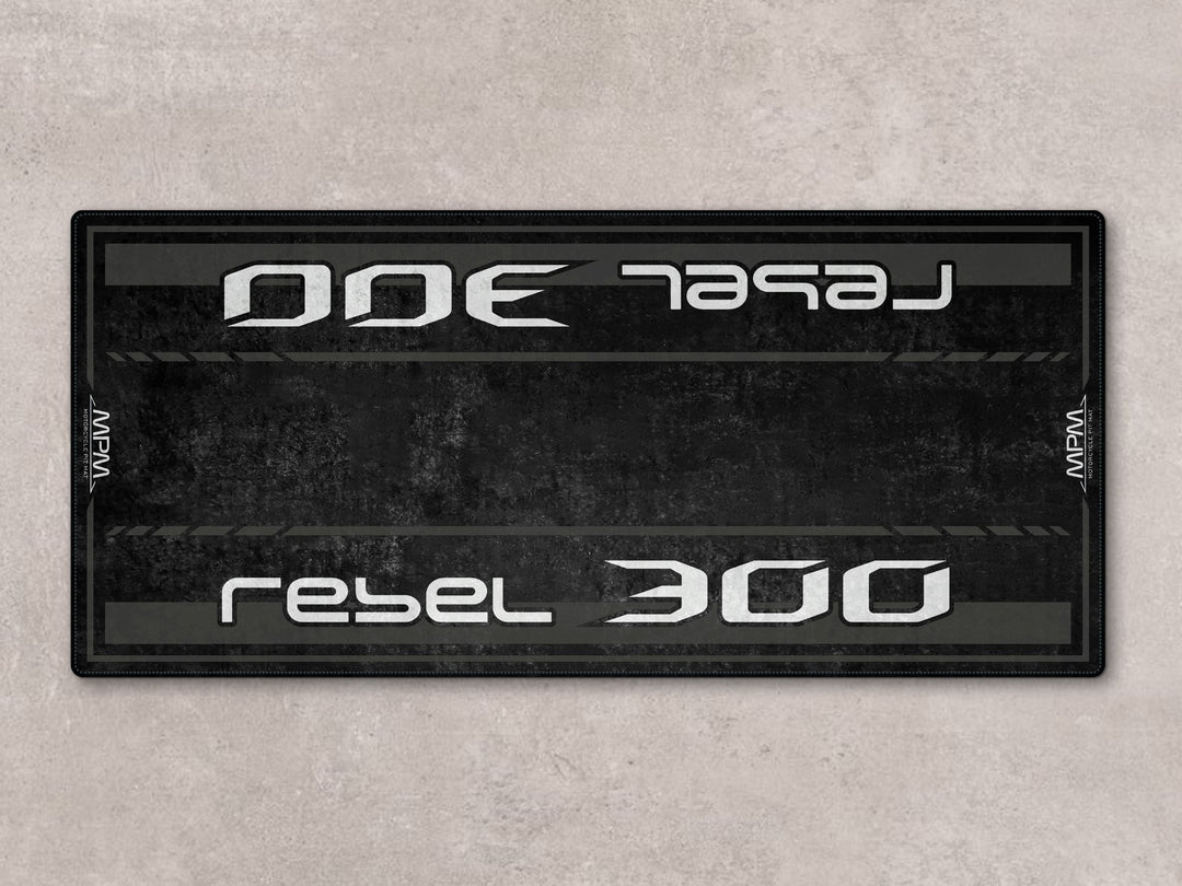 Rebel 300 pit mat in black. Durable floor cover and parking mat ideal for garage setups and daily rider use.