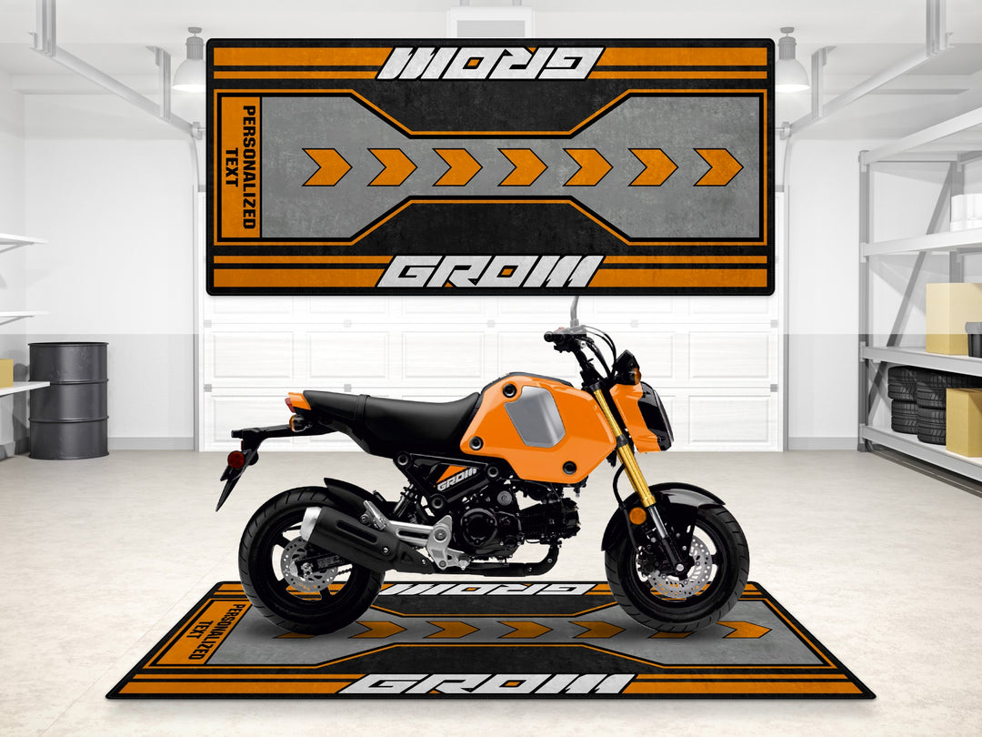 Custom pit mat for Honda Grom in vivid orange. A motorcycle accessory for racetrack or showroom setups.
