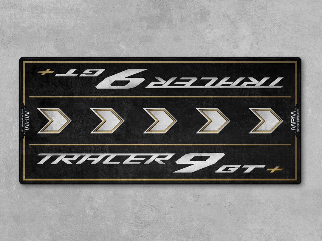 Black and gold Thermoplastic Rubber motorcycle mat for Tracer 9 GT+, protects garage floor with style and performance.