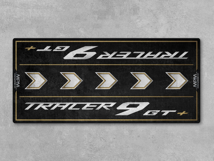 Black and gold Thermoplastic Rubber motorcycle mat for Tracer 9 GT+, protects garage floor with style and performance.