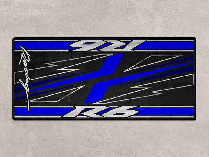 R6 blue racing pit mat with bold X design, perfect rug for parking, parts protection, and superbike garage setups.