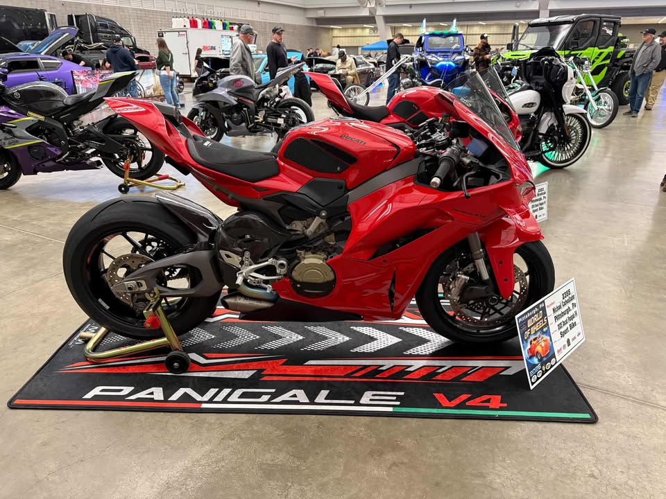 Ducati Panigale V4 on custom motorcycle pit mat at indoor bike show, non-slip floor cover for superbike display.