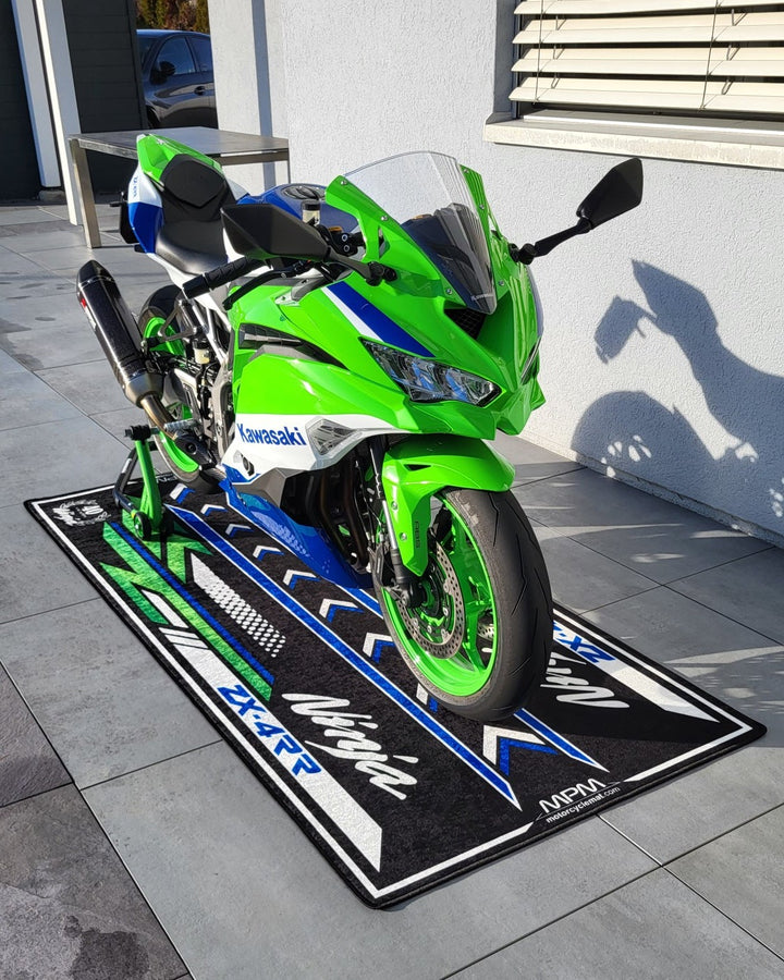 Kawasaki ZX-4RR motorcycle pit mat in real outdoor garage setup, non-slip floor cover for sportbike display and track prep.