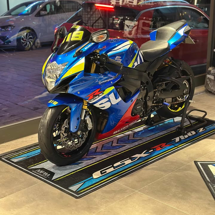 Suzuki GSX-R 750 supersport motorcycle on garage pit mat, durable non-slip floor rug for track-ready setup.