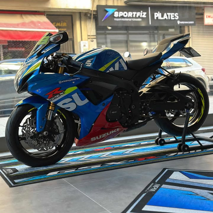 Suzuki GSX-R 750 on custom motorcycle pit mat in indoor showroom, non-slip floor cover for sportbike display.