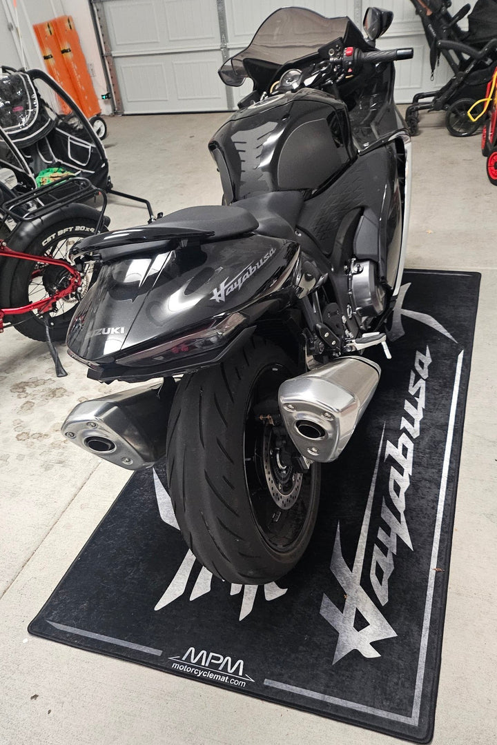 Suzuki Hayabusa on custom motorcycle pit mat in indoor garage, non-slip floor cover for hyperbike display.