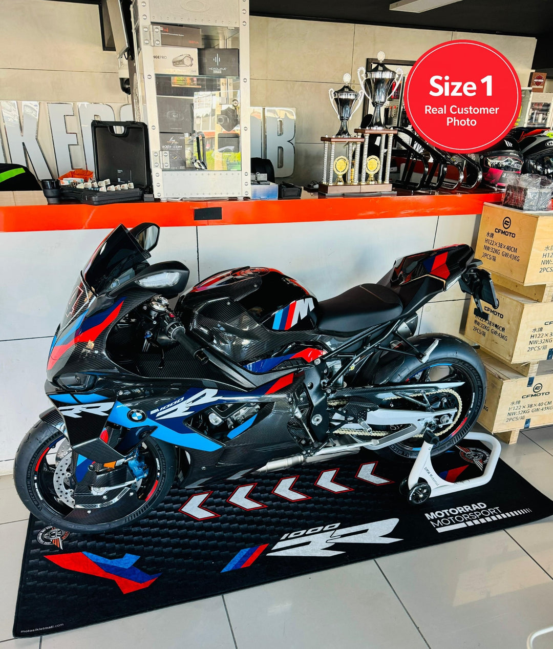 BMW M1000RR superbike on garage pit mat, durable non-slip motorcycle floor rug for track-ready setup.