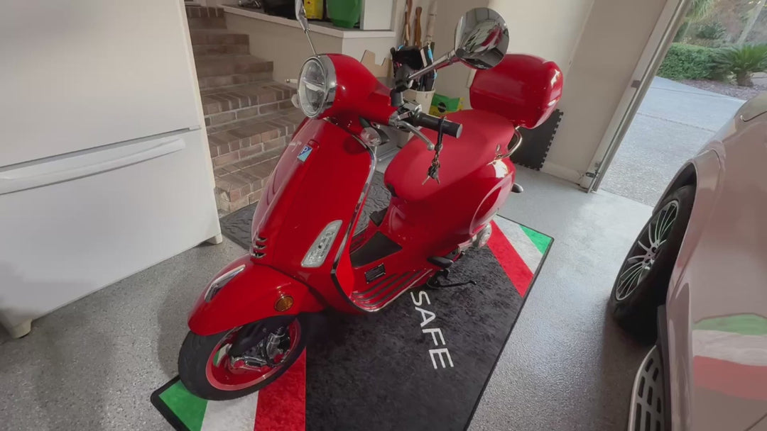 Vespa scooter garage pit mat with Italian color design, non-slip motorcycle floor rug for showroom display.