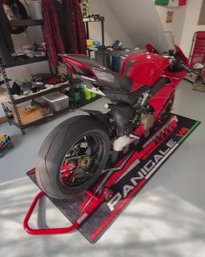 Ducati Panigale V4 superbike display on custom pit mat, non-slip motorcycle floor cover in real show environment.